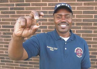 Neil Heller, an assistant chief of the Warren Fire Department, holds the bullet that he found on the street outside a house on Fourth Street Southwest on Tuesday morning. He found the bullet just after feeling a sharp stinging in his thigh. Heller was not injured.