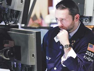 Specialist Christopher Gildea works on the floor of the New York Stock Exchange on Tuesday. U.S. stocks traded solidly higher Tuesday after European markets rallied and corporate bellwether Alcoa predicted stronger demand in 2012.