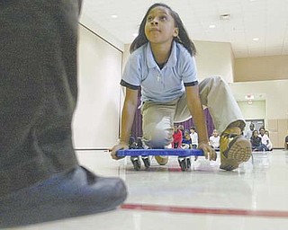 Desiree D’Altorio, a fourth-grader at Taft Elementary School, Youngstown, rolls into the Relay for Learning at the school. Students, divided into teams, race to the front of the gymnasium, answer a question and race back.