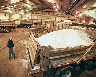 Gary Setz, highway maintenance supervisor with the Mahoning County engineer’s office, inspects the salt-truck fleet Thursday as it stands ready in the garage to keep county roads safe for motorists as the predicted snow
flies today.