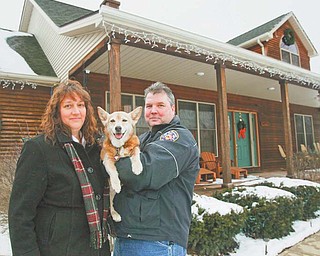 Sandy and Mark Mangan with their dog, Lou, stand outside their State Road home in Granger Township near Medina. Their home is one of two in Medina County that have been deemed a public-health threat by a federal health agency because of potentially explosive levels of natural gas in their drinking water.