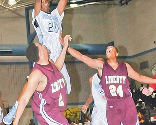 Youngstown East’s Terrell McClain (20) puts up a shot over Liberty’s David Hight (2) and Jamaal Daniel (24) during their game Tuesday at East High.