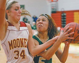 Aurielle Irizzary (5) of Ursuline attempts to drive past Cardinal Mooney’s Taylor Woytek (34) during the second period of their basketball game Thursday at Cardinal Mooney High School. The Irish defeated the Cardinals, 38-28.
