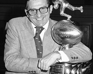 Joe Paterno, head coach of the Penn State Football Team, clutches the Lambert Trophy in New York on Dec. 6, 1973 after it was awarded to his team as emblematic of collegiate grid supremacy in the east. (AP Photo/Dave Pickoff)