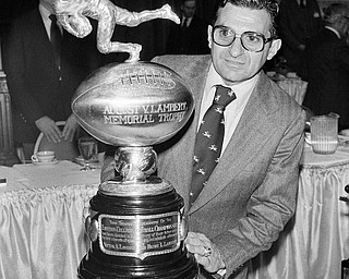 Penn State football coach Joe Paterno, poses in New York, Thursday, Nov. 30, 1978, with the Lambert trophy, honoring Penn State as the best major college team in the east Paterno insisted emphatically at the New York luncheon that he has no desire to move into pro ranks amid speculation that he might succeed John McVay as coach of the New York giants in the national football league. (AP Photo/Burnett)