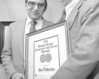 Penn States? Joe Paterno, left, accepts the Bobby Dodd Coach of the Year Award from former Georgia Tech coach Bobby Dodd at a lunch presentation, Wednesday, March 11, 1982 in Pittsburgh. The award recognizes a style of coaching that emphasizes more than the winning of game. (AP Photo/Gene J. Puskar)