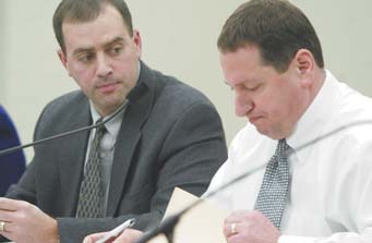 Liberty Board of Education President Joe Nohra, right, reads a list of more than $1 million in cuts to district personnel as board Vice President David Malone looks on. The cuts will go into effect at the beginning of fiscal year 2013, which begins July 1.