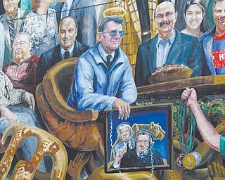 A halo was added Monday above the likeness of legendary Penn State football coach Joe Paterno on the
mural outside a student bookstore in State College, Pa.. Paterno died Sunday after a brief battle with lung
cancer. He was 85.