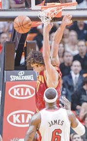 Cleveland Cavaliers’ Anderson Varejao dunks in front of Miami Heat’s LeBron James (6) during the first half of a game Tuesday in Miami.