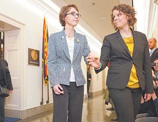 Rep. Gabrielle Giffords, D-Ariz., assisted by her chief of staff, Pia Carusone, leaves her office on Capitol Hill in Washington on Wednesday for the last time as a member of Congress.