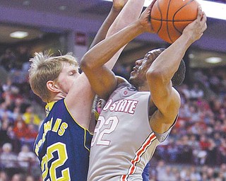 Ohio State’s Lenzelle Smith Jr., right, shoots over Michigan’s Blake McLimans during the second half of an NCAA
college basketball game Sunday in Columbus. Smith scored 17 points and had a career-high 12 rebounds as the
Buckeyes defeated the Wolverines 64-49.