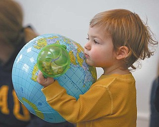 William Garrett, 21 months, of Canfield, carries the world in his hands at a Baby Brilliant early-literacy session at the Poland Branch of the Public Library of Youngstown and Mahoning County.