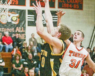 Crestview’s C.J. Collins shoots as Springfi eld’s Ron Rogers (31) watches during their game on Tuesday in New
Middletown. The Tigers See TIGERS, B4 won, 61-52.
