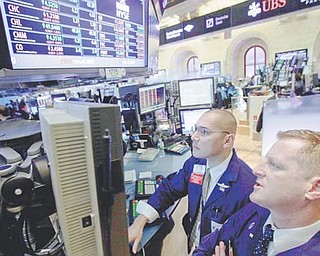 Specialists Mark Otto, left, and Christopher Malloy work on the floor of the New York Stock Exchange on
Monday. Markets clawed back lost ground Tuesday on hopes that Greece is heading toward a conclusion
of debt-reduction talks with private creditors and that it may secure its second bailout package this week.