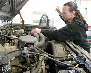 Mike Corps checks fluid levels after servicing a truck at Boardman Auto on Indianola Road. Corps said he has been swamped with customers since he opened at the beginning of the year, many of whom are trying to maintain their vehicles for as long as possible.