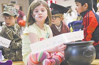 First-grader Grace Gromada, 7, waits her turn Wednesday to go before the audience at St. Charles School to give the definition of “rainbow” at the Boardman school’s Vocabulary Parade.