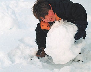 Aaron Hartsough of Canfield is either building a snowman or a really big snowball. Photo sent by Lana VanAuker of Canfield.