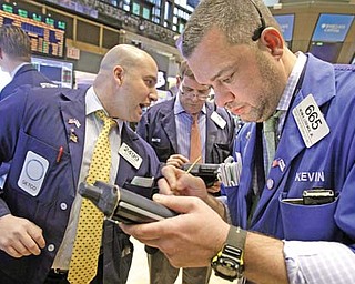 Trader Kevin Lodewick, right, works on the fl oor of the New York Stock Exchange. A strong one-day
rally — caused by a deal to lock down badly needed bailout money for Greece, perhaps, or another
unexpectedly positive economic report — could put the Dow over the 13,000 mark.