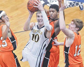 McDonald’s Christian Rusinowski (10) muscles up a shot over Wellsville’s Seth Bradford, right, Jordan Sloan,
left, and Josh Carter during their game Tuesday at McDonald.