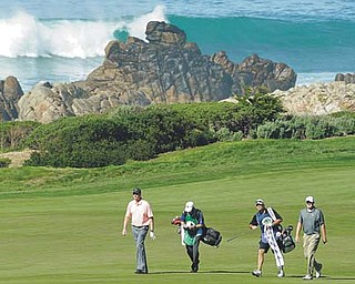 Golfers Kevin Kisner and Jason Kokrak (far right) — their caddies between — walk down the 10th fairway of the picturesque Monterey Peninsula Course during Round 1 of the Pebble Beach National Pro-Am on Thursday. Kokrak, a Warren native, finished the round at 2-under 68. He and Kisner will play Round 2 on the Pebble Beach Golf Links today.