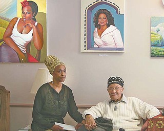 Joseph L. Thomas, 91, of Youngstown, and his wife, Gwendolyn, pose below two of his art pieces — singer Stephanie Mills and Oprah Winfrey — on display for Black History Month at the Dandridge Burgundi Manor care center on Maranatha Court on the city’s East