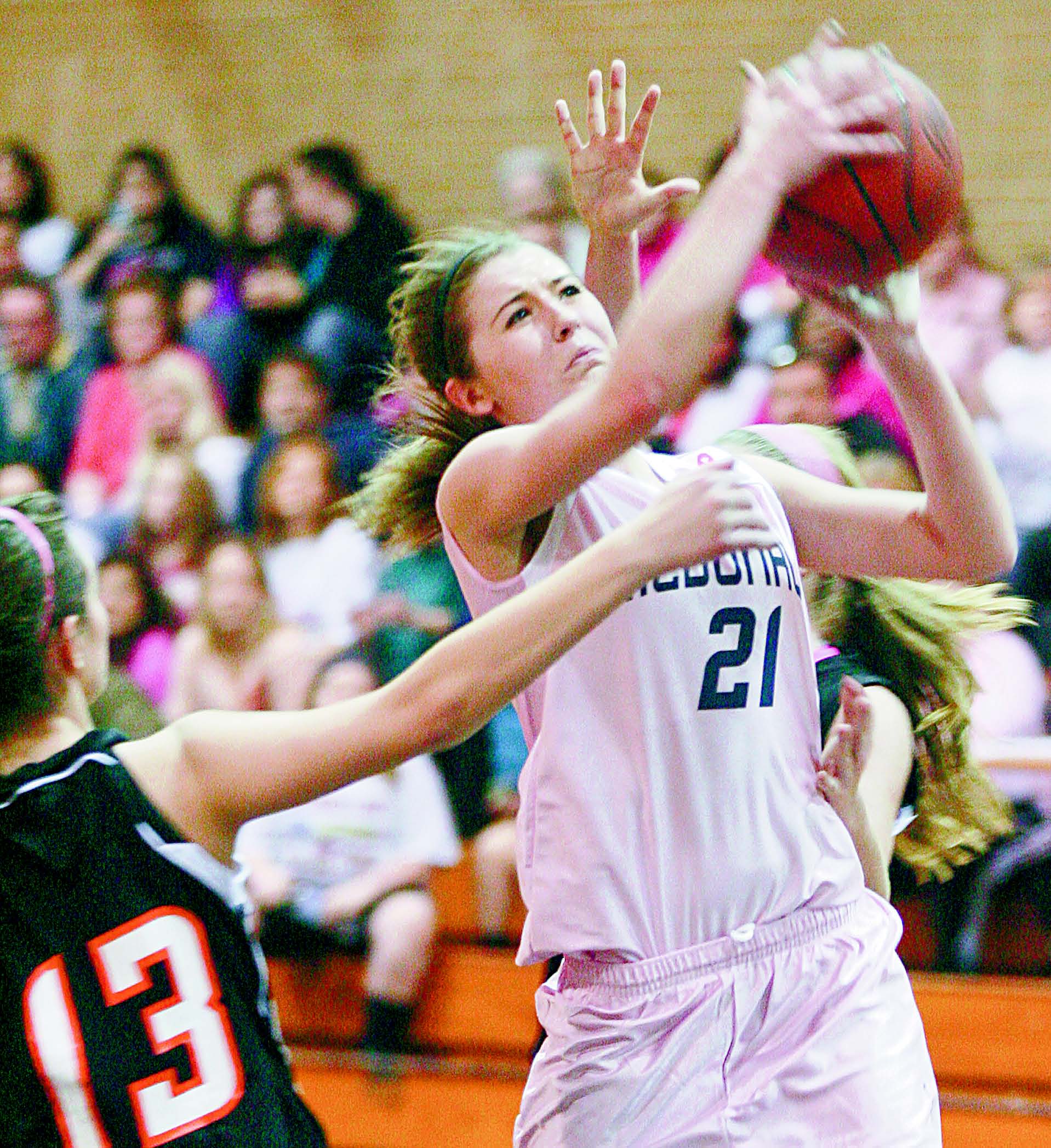 McDonald’s Taylor Stanley (21) pushes through Mineral Ridge defenders to take a shot during the first period of Wednesday’s game in McDonald. Stanley, a senior, scored her 1,000th career point in the Blue Devils’ 44-31 win over the Rams.