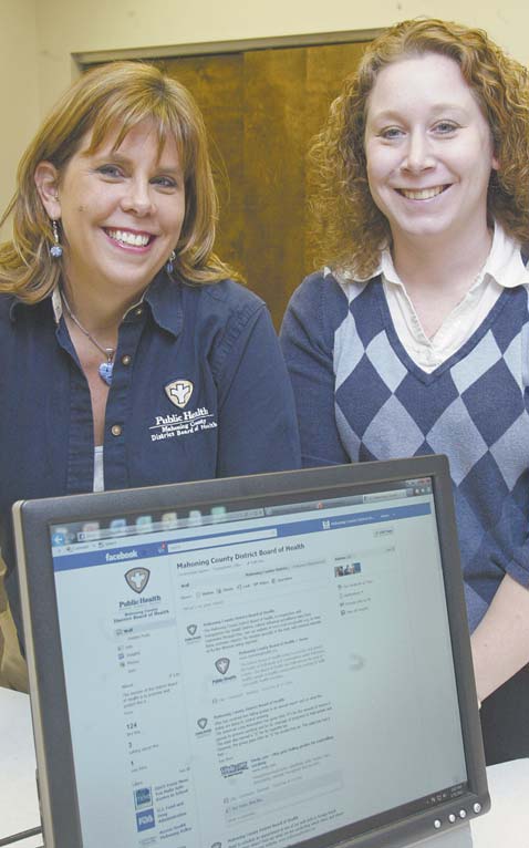 Tracy Styka, left, and Susan Kovach of the Mahoning County District Board of Health with the Facebook page they created to help inform the public in the event of a health emergency.