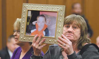 Family member Trish Boone holds a photo of Willie Robinson duringsentencing Feb. 16 in Cleveland for his parents, William Robinson Sr. and Monica Hussing, formerly of Warren. The parents of the 8-year-old
who died from Hodgkin’s lymphoma, after suffering undiagnosed for months, were each sentenced to eight years in prison.