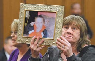 Family member Trish Boone holds a photo of Willie Robinson duringsentencing Feb. 16 in Cleveland for his parents, William Robinson Sr. and Monica Hussing, formerly of Warren. The parents of the 8-year-old
who died from Hodgkin’s lymphoma, after suffering undiagnosed for months, were each sentenced to eight years in prison.