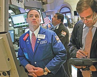 Traders work on the floor at the New York Stock Exchange in New York on Tuesday. U.S. stocks crossed
13,000 Tuesday for the first time since May 2008, and closed at 12,965.69.