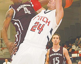 Boardman defender T.J. Irving (4) blocks a shot by Austintown Fitch’s Nate Blair during Tuesday’s game in Austintown. The Falcons won the rivalry game, 67-37.