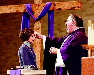 With the words, “Repent, and believe the Gospel,” the Rev. Philip Rogers, of St. Charles Borromeo Church in Boardman, makes the sign of the cross in ashes on the forehead of Ann Moran of Boardman during a noon Ash Wednesday Mass. Ash Wednesday is the start of Lent.