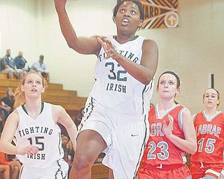 Ursuline’s Courtney Powell (32) drives to the hoop during the Irish’s Division III sectional basketball game Thursday against the LaBrae Vikings at Mineral Ridge High School. Ursuline dominated LaBrae, 58-26.
