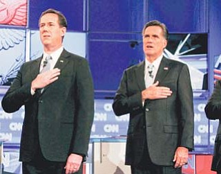 Republican presidential candidates former Pennsylvania Sen. Rick Santorum, left, and former Massachusetts Gov. Mitt Romney stand together for the national anthem before the start of a Republican presidential debate Wednesday in Mesa, Ariz.