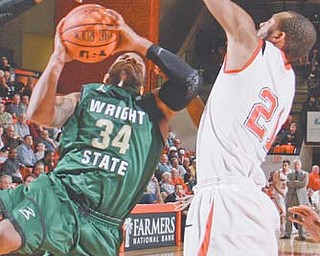Youngstown State’s Damian Eargle (21) attempts to block a shot by Wright State’s Julius Mays (34) during
the second half of their Horizon League game Thursday at YSU’s Beeghly Center. The Penguins downed the
Raiders, 61-54. Eargle, who scored eight points and had 13 rebounds, also finished with five blocks to claim
the Horizon League record for blocks for an entire season.