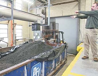 Howard Zickefoose, acting superintendent of the Girard waste-water treatment plant, shows the final processed waste product to be sent to a landfill. The new equipment is expected to generate about $180,000 in additional revenue for Girard annually.