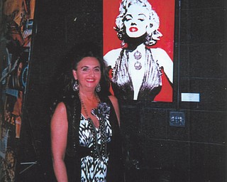 Deborah Carissimi of Boardman stands by some of her artwork on display at Youngstown Playhouse.