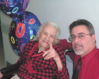 Eva Green, a resident at Danridge's Burgundi Manor in Youngstown, wore red when she turned 100 years old last week. With her is facility administrator David Tikkanen.