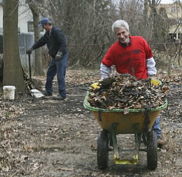 JESSICA M. KANALAS | THE VINDICATOR..Blake, new to the North side, wheels a load of garbage and debris to a dumpster during a clean-up day held at his home on Lora Ave.