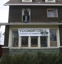 JESSICA M. KANALAS | THE VINDICATOR..Ron Major of the North side replaces windows on the second floor of Blake's new home. Major works for Youngstown Contracting which donated their workers time to come out and help the crew fix up the new house on Saturday.