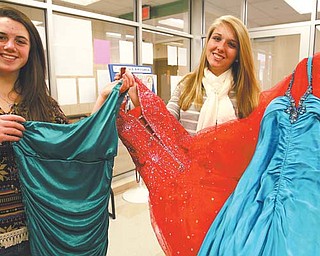 West Branch High School seniors Dottie Schlueter, left, and Mackenzie Shivers show off a few of the prom dresses donated for Project Prom. The program collects used prom dresses and offers them at no charge to high-school girls who need them. The dresses will be available from noon to 4 p.m. March 31 at the Salem Schools administration building, 1226 E. State St.