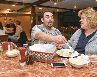 Dustin Shamp tries to sample a bite of fish from his fiancée, DeAnna Hardwick, of Poland at the weekly fish fry at the Youngstown Maennerchor on Mahoning Avenue. The couple has been coming to the dinners for years.