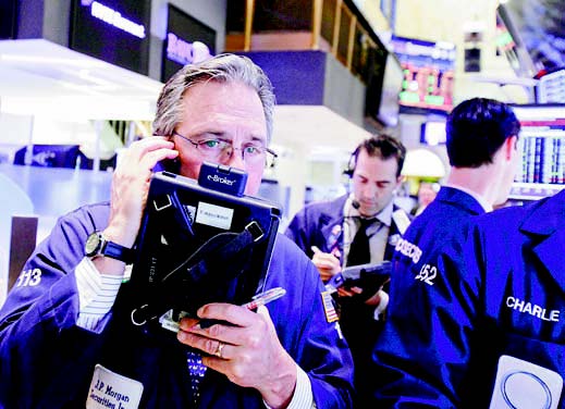 Trader Thomas Kay, left, works on the floor of the New York Stock Exchange on Friday.