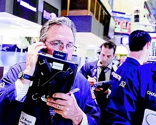 Trader Thomas Kay, left, works on the floor of the New York Stock Exchange on Friday.