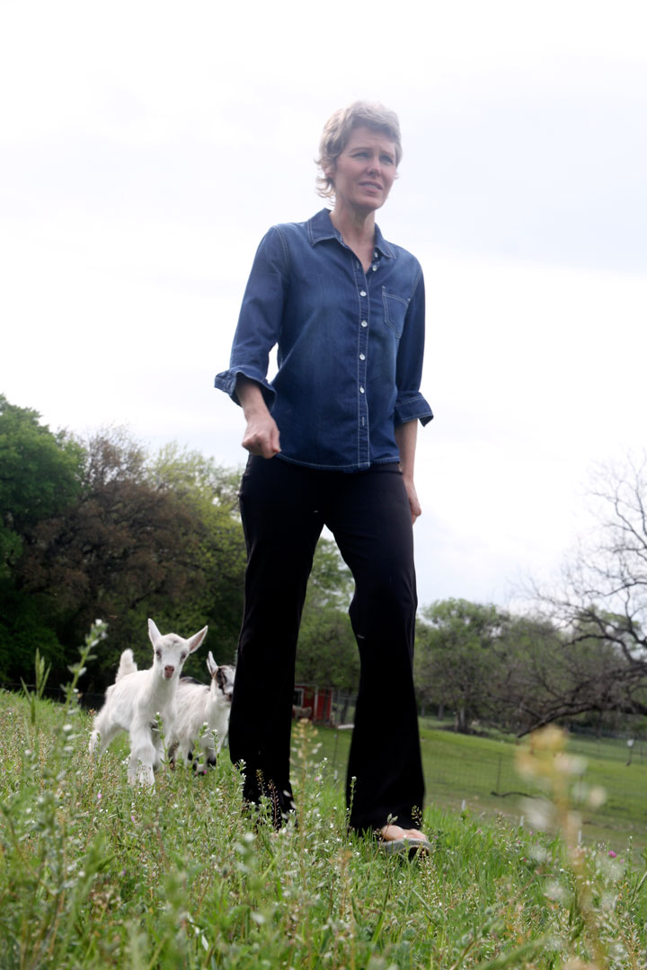 Deborah Rogers, a Westworth Village resident, walks toward a nearby gas well with two of her baby goats, George, left, and Blossom.