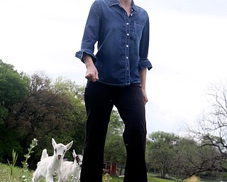Deborah Rogers, a Westworth Village resident, walks toward a nearby gas well with two of her baby goats, George, left, and Blossom.