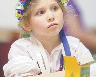 Kataryna Flasher, 6, of Youngstown, above, watches the palm-weaver demonstration during the Polish Easter Traditions Workshop and Celebration on Sunday.