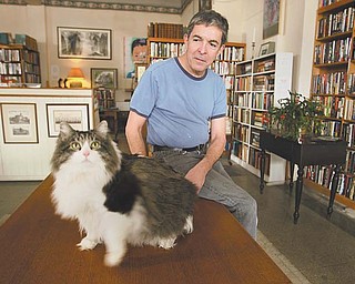 A familiar fixture at Dorian Books, a used bookstore on Youngstown’s North Side, is Ernest Hemingway, a 28-pound, 8-year-old cat, adopted from a Columbus animal shelter. Ernie, named after the renowned novelist, is shown with his owner, Jack Peterson, bookstore co-owner.