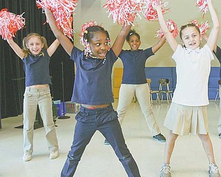 William Holmes McGuffey Elementary School second-graders Markeysha Dozier, 8, front, and from left, Jaci
Vittorio, 8; Myah Diana, 8; and Ranya Scott, 8, demonstrate a cheer they performed Thursday during lunch
to encourage older students to do well on the Ohio Achievement Assessment tests next month.