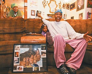 Maggie Williams, far left, and her daughter, Reice Williams, spoke to The Vindicator near a drawing of the five children of Julius Williams, framed and surrounded byimages of Julius and his family. Julius was killed by his wife, Monique, in 2008. Mylah Arington, 3, stayed close to her mother as the child listened to stories about
the uncle she never got the chance to meet.